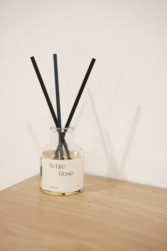 White Rose reed diffuser on a wooden table